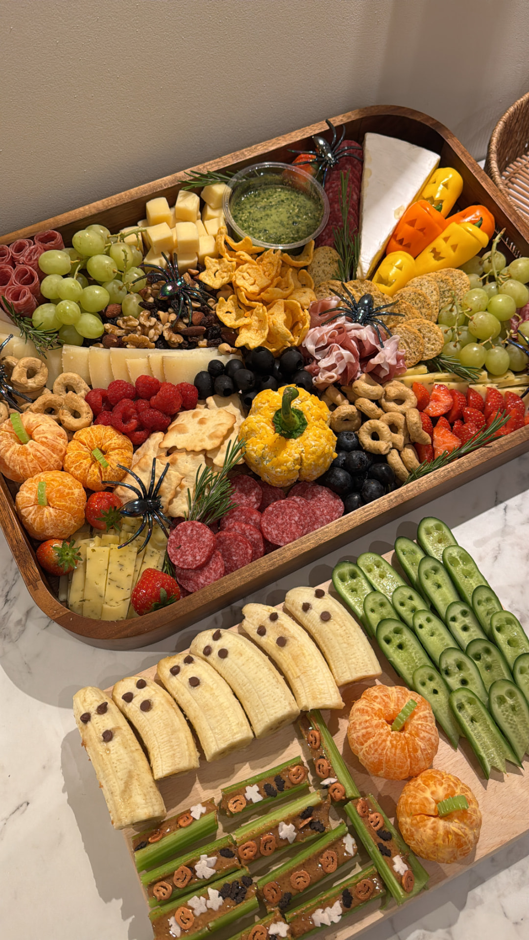 Halloween grazing board with pumpkin mandarins, banana ghosts, cucumber spears and spider details
