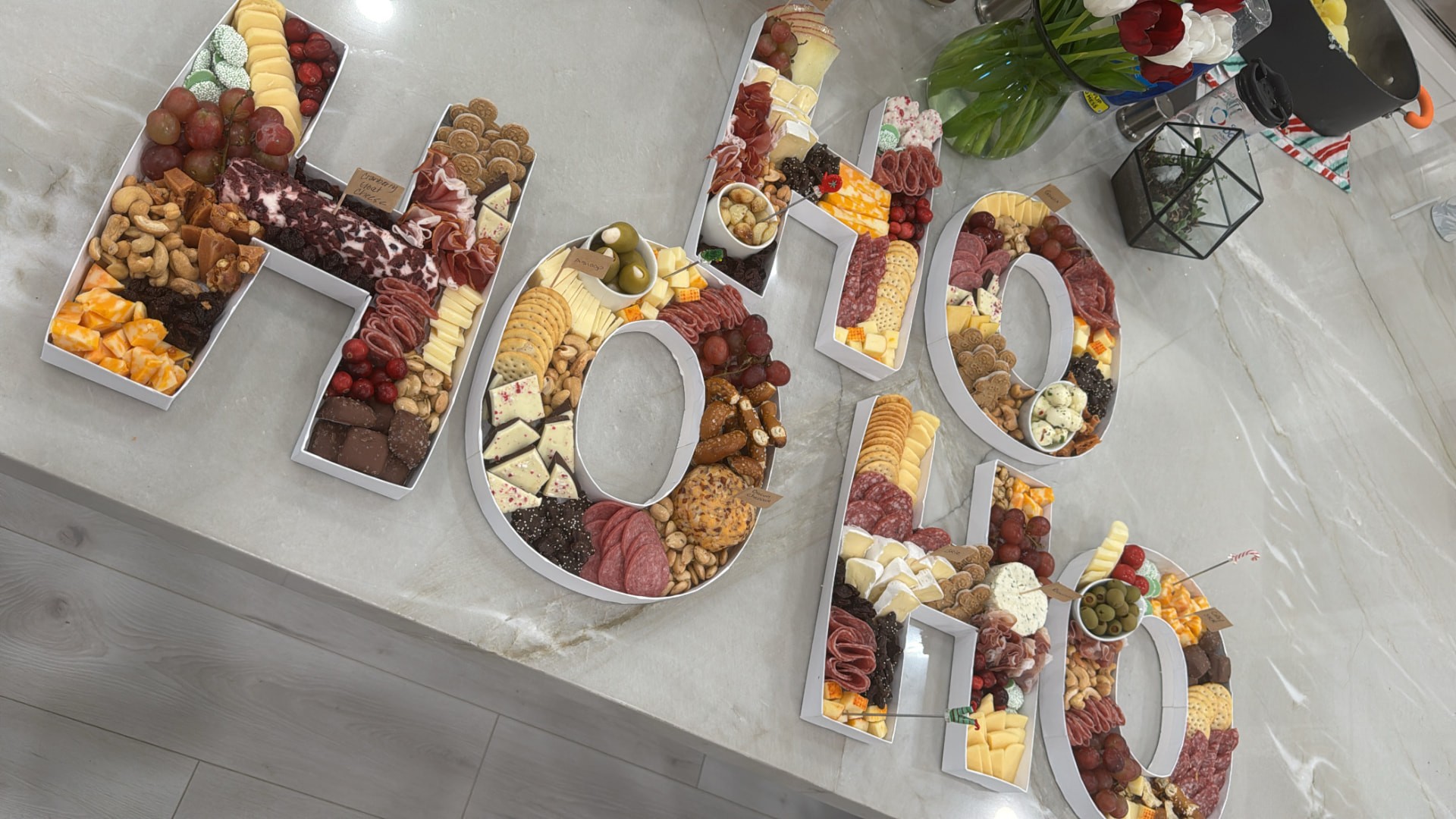 HO HO HO holiday letter trays with cheeses, cured meats, crackers, grapes and sweets