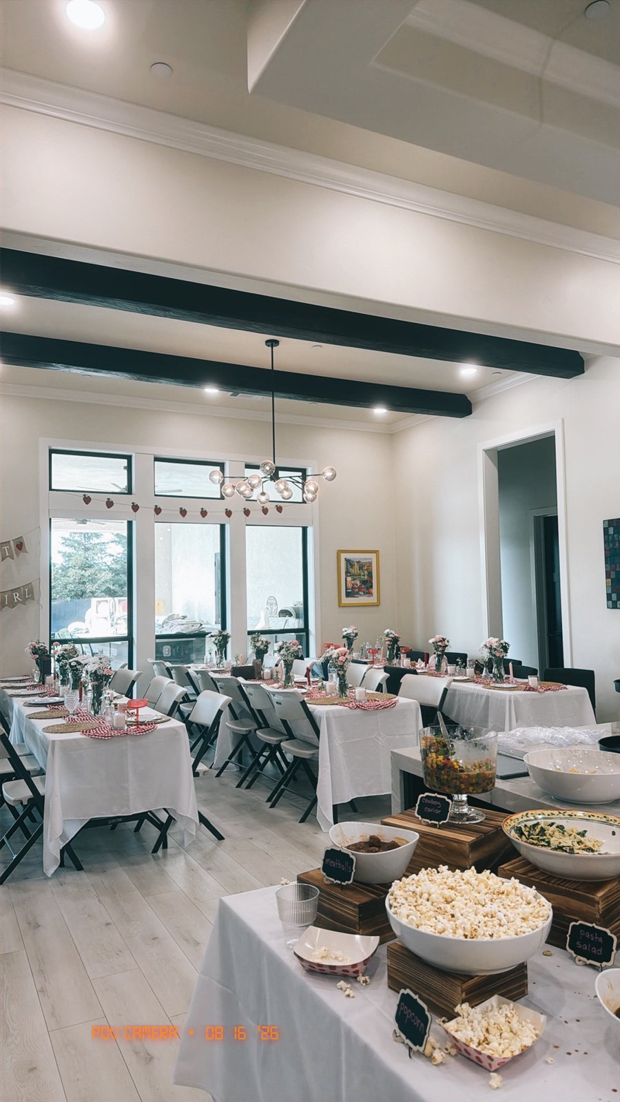 The dining room with long guest tables, strawberry bunting and the food station