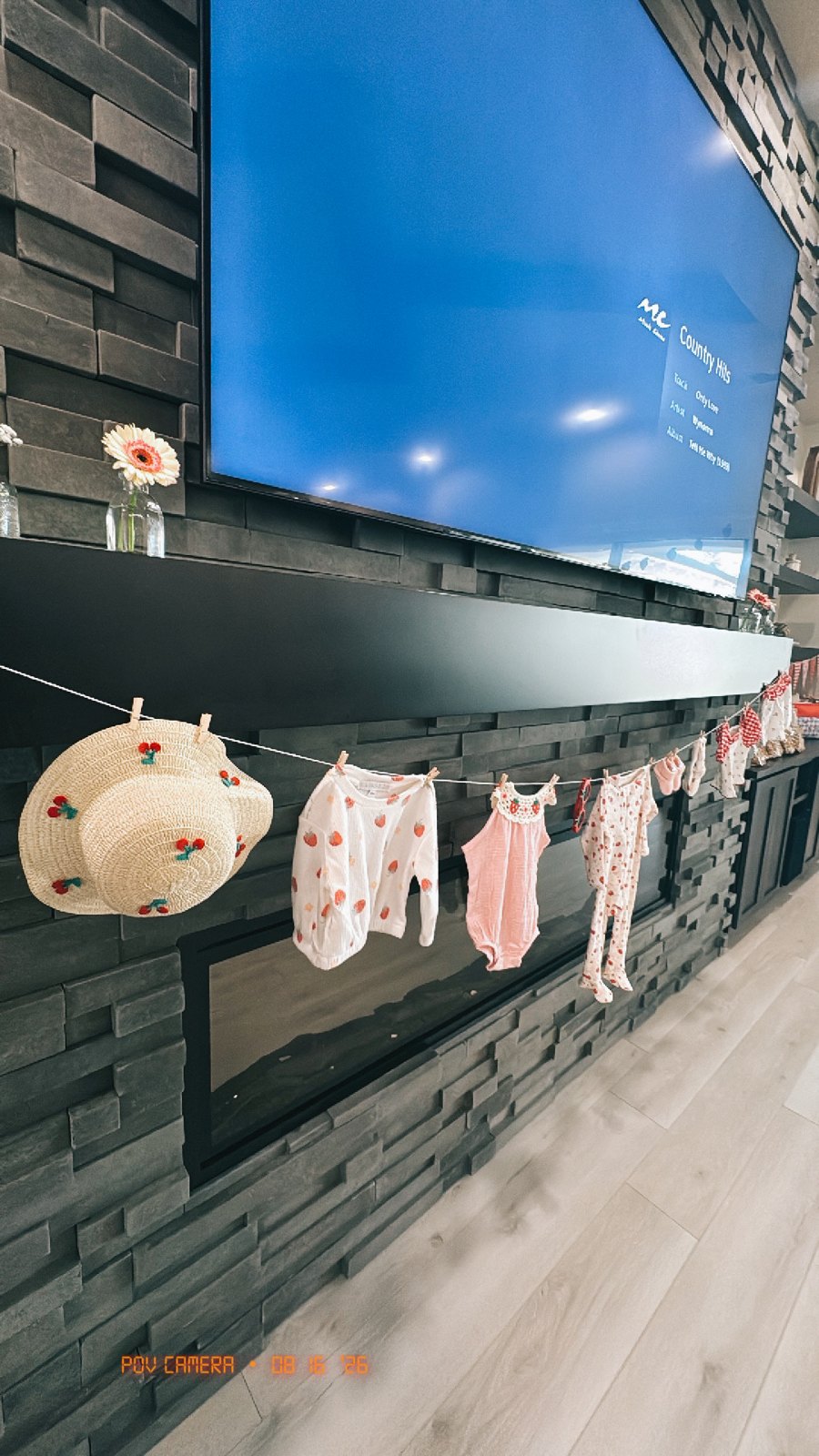 Strawberry baby outfits and cherry sun hats pegged along a clothesline