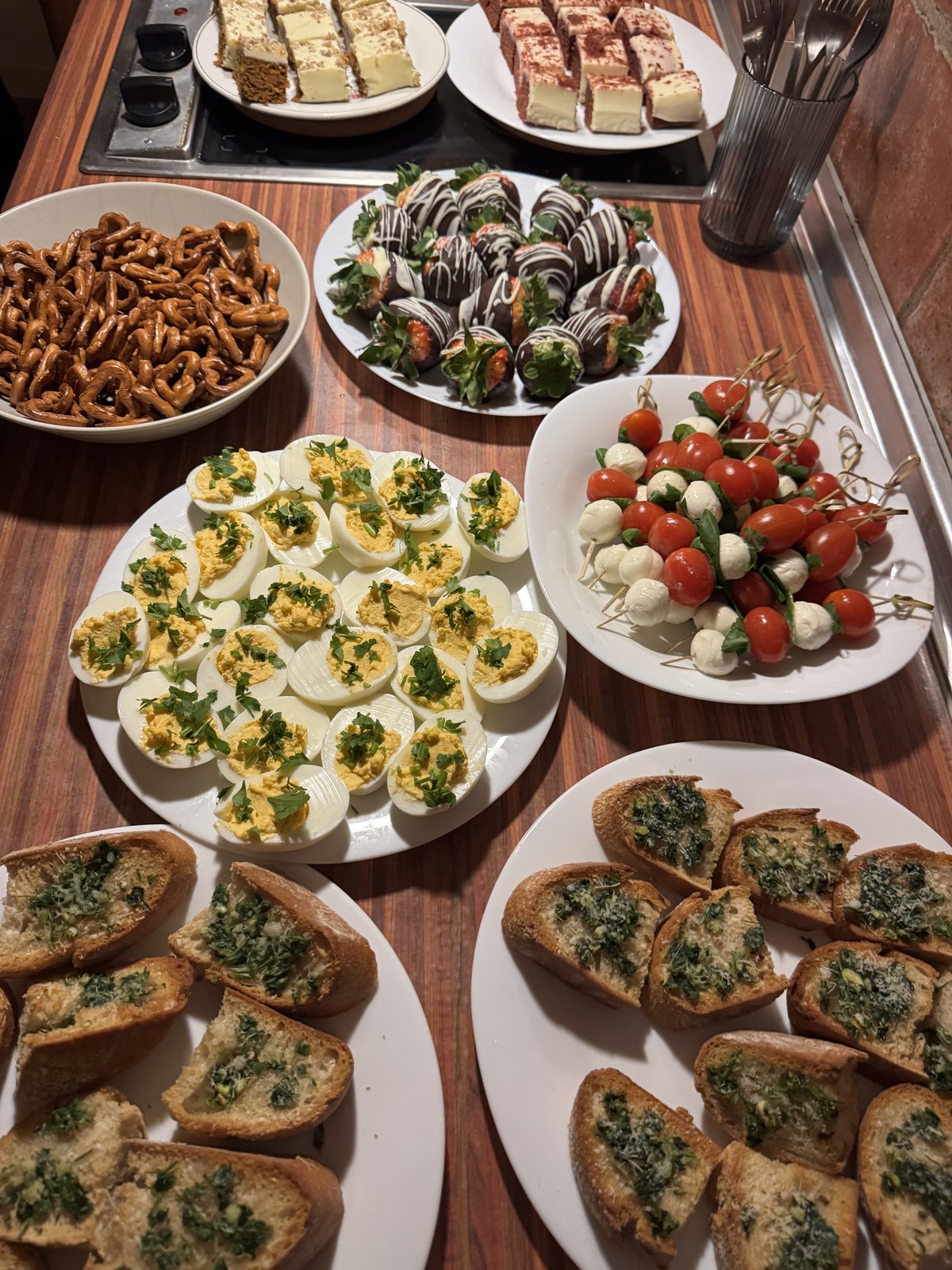 Galentine's Day spread — deviled eggs, caprese skewers, garlic bread, chocolate-covered strawberries and desserts