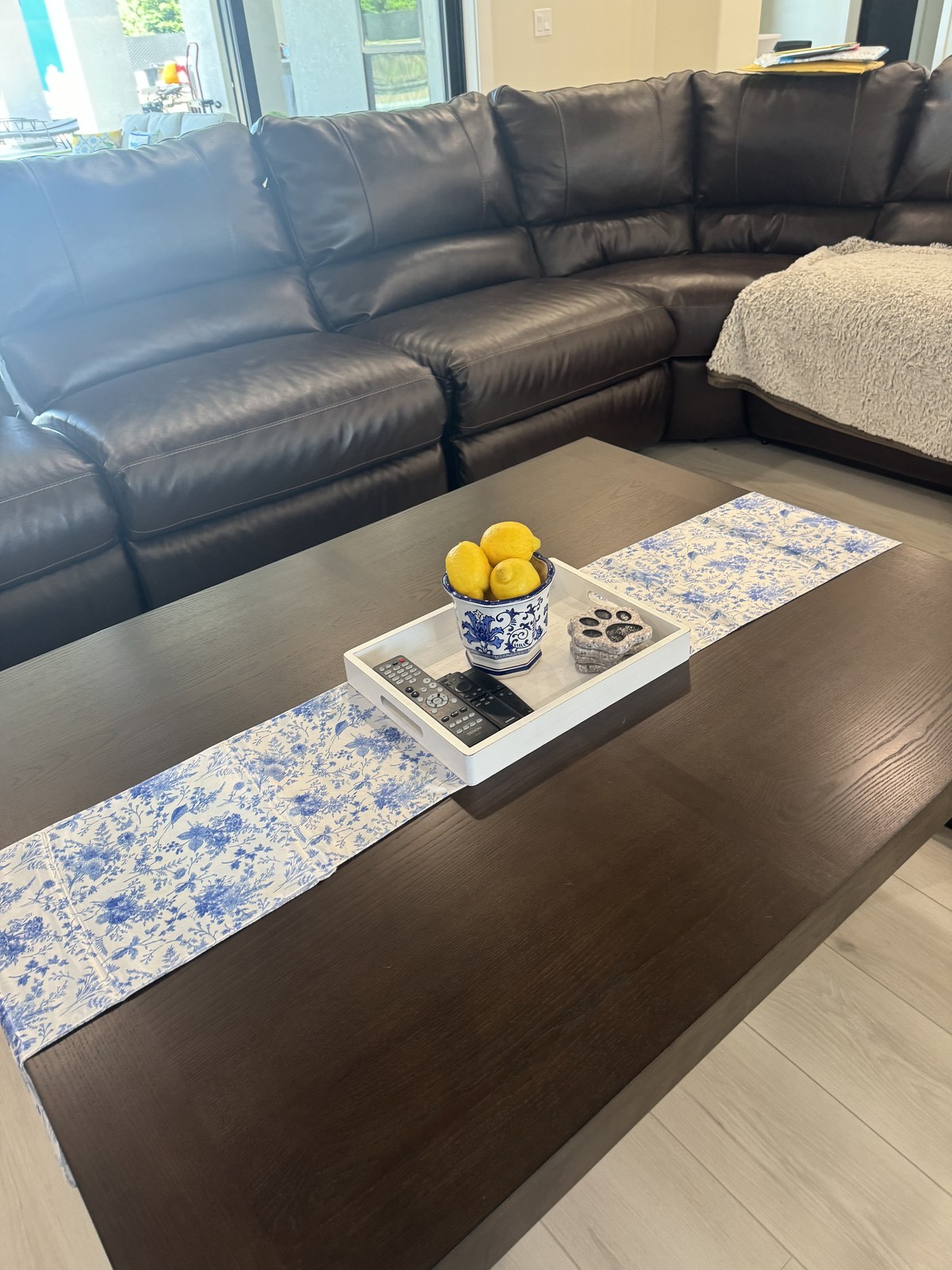 Living room table detail with blue floral runner and a bowl of lemons