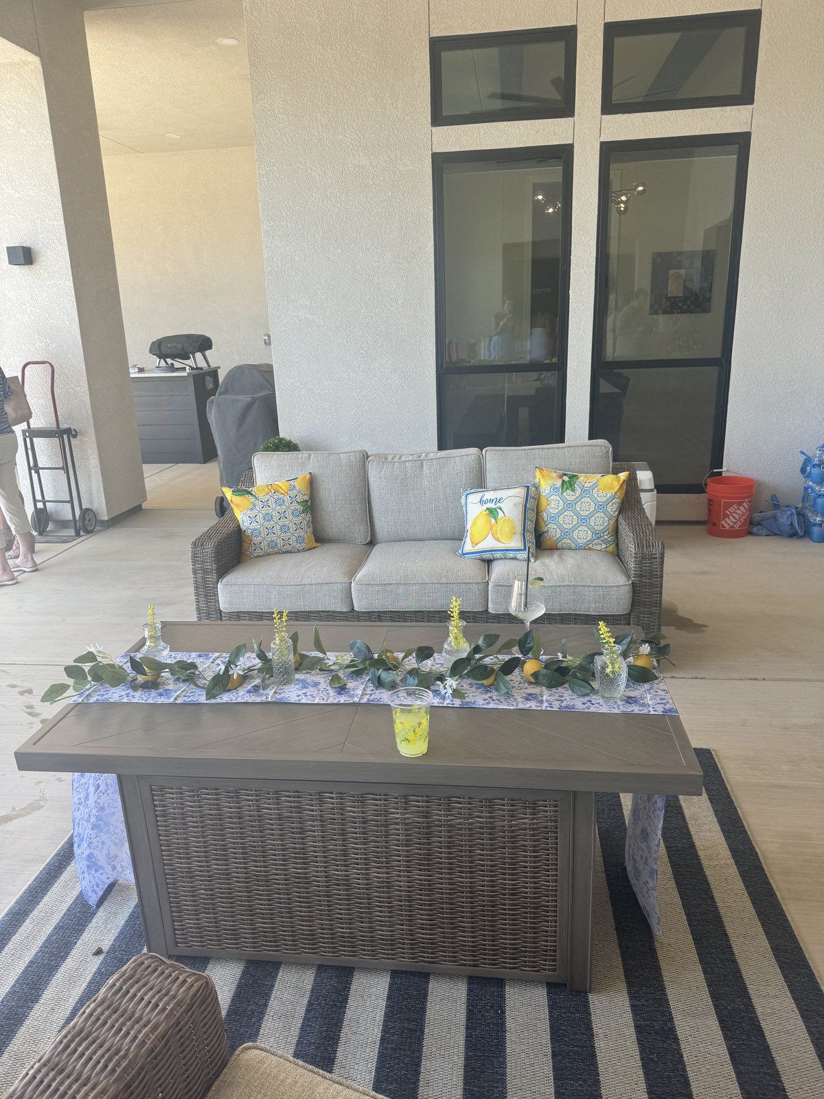 Outdoor lounge with lemon pillows, eucalyptus garland and blue floral runner
