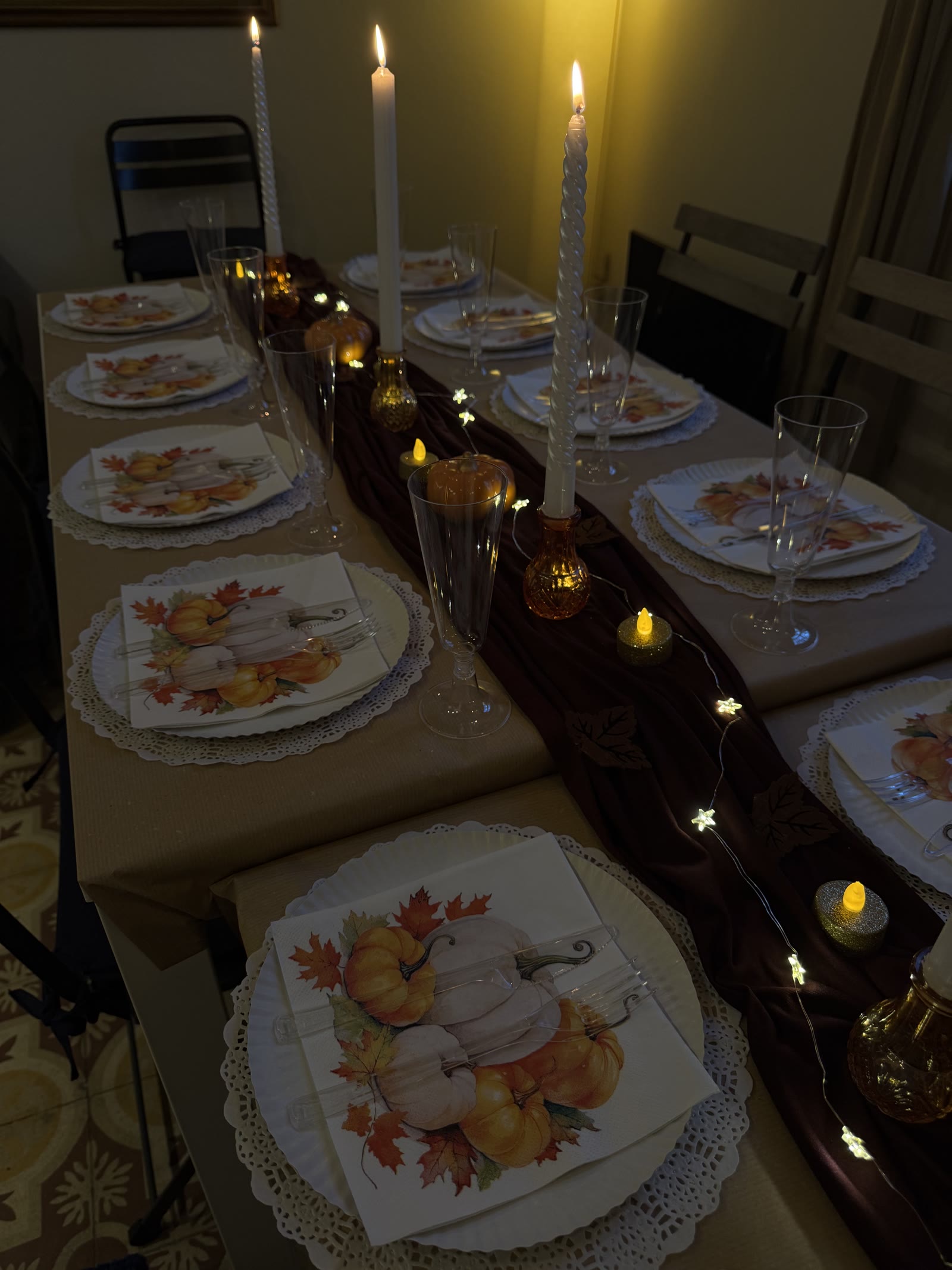 Thanksgiving table detail — candlelight, autumn napkins and gold tea lights